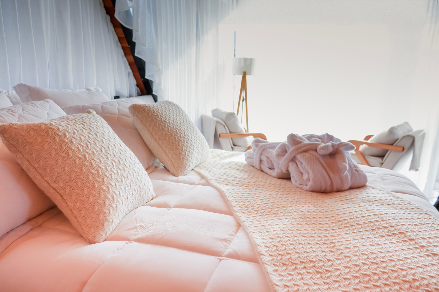 Cama queen com roupa de cama Trussardi e roupões